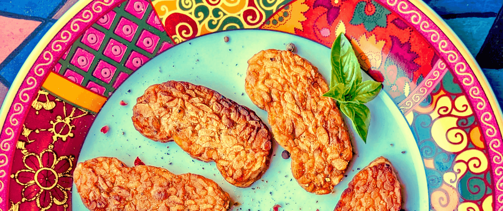 Quatre tempeh marinés colorés sur une assiette artisanale